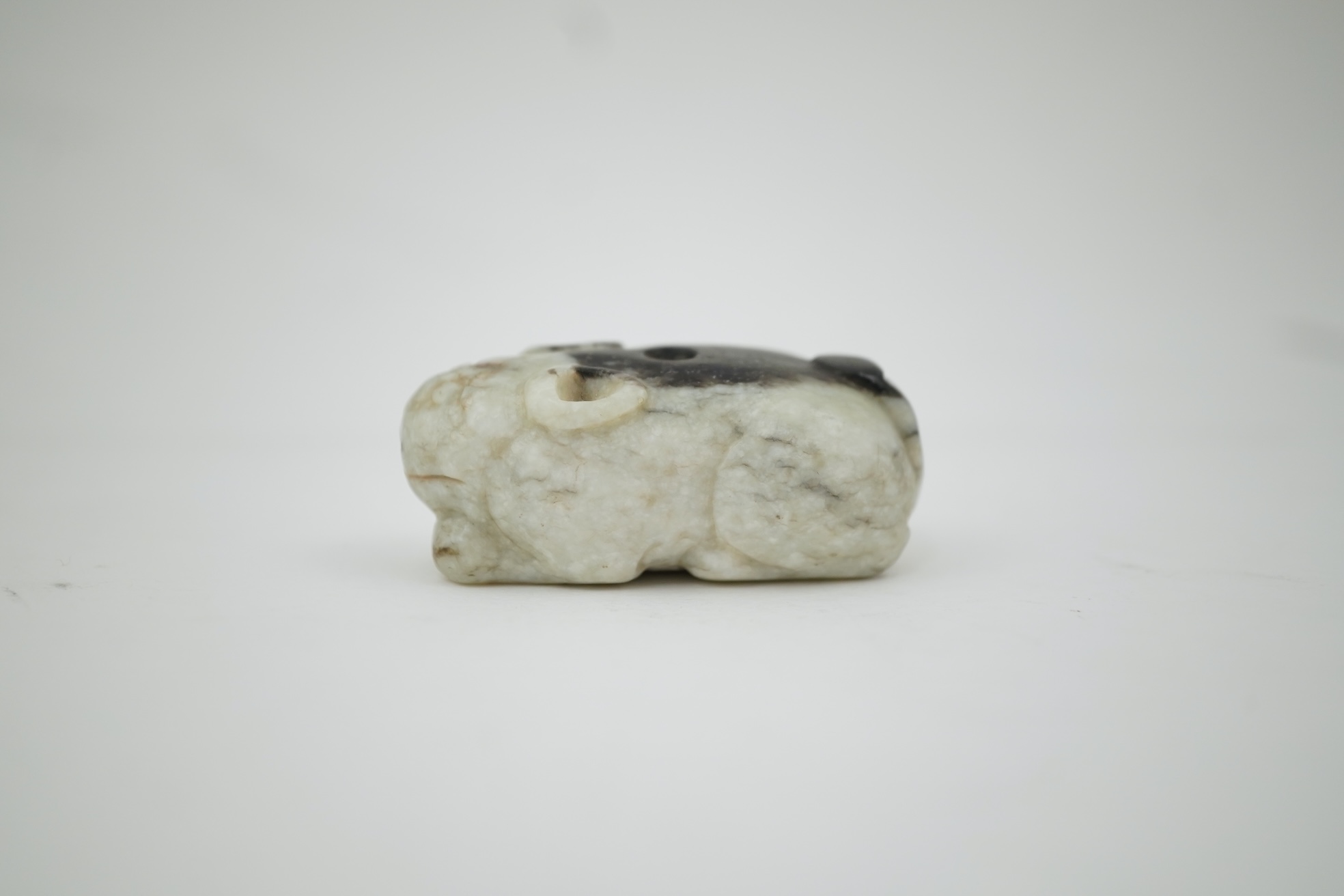 A Chinese white and black jade figure of a recumbent tiger, Song dynasty